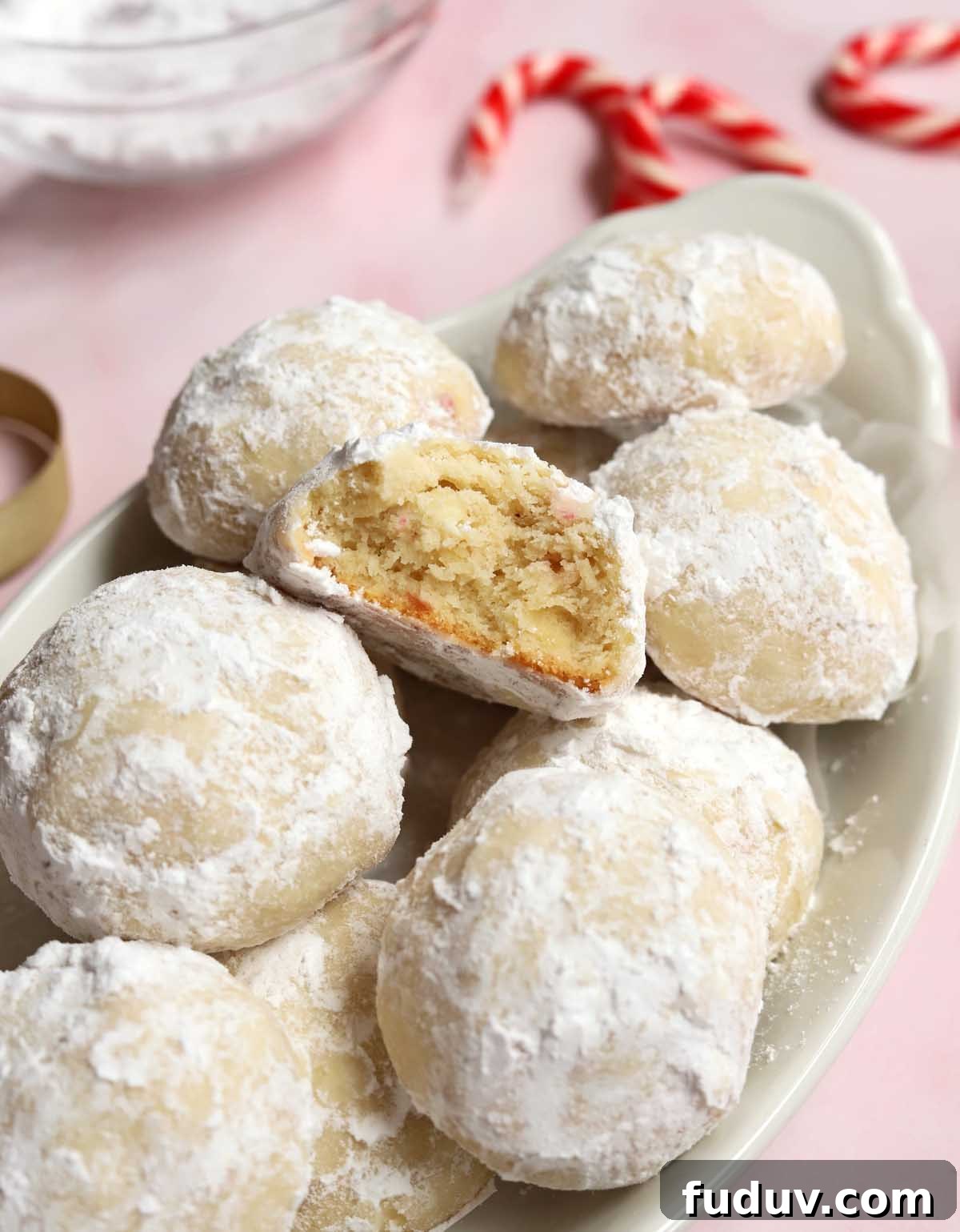 peppermint snowball cookies in a serving dish with bite showing tender insides