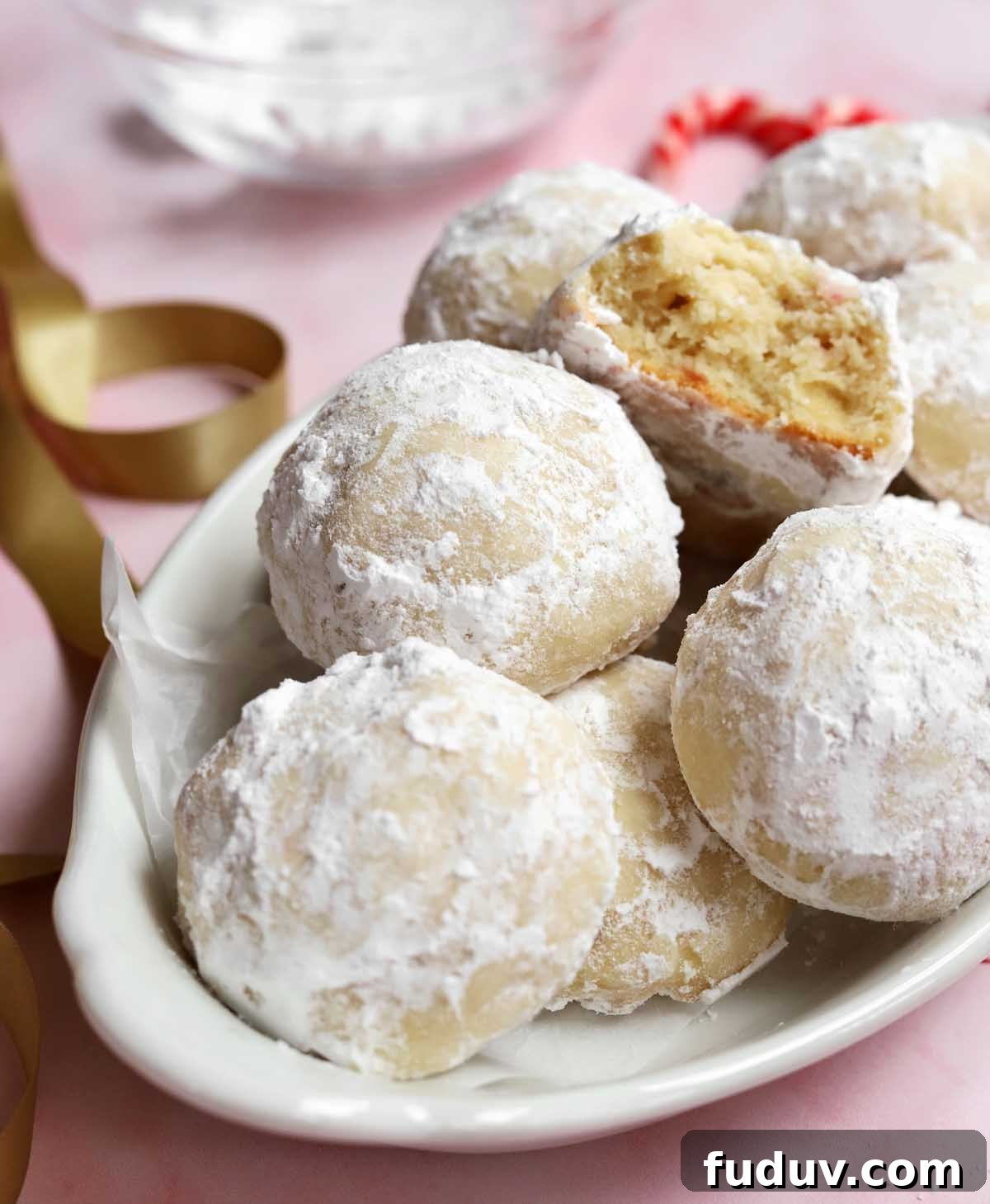 peppermint snowball cookies in a serving dish with bite showing tender insides