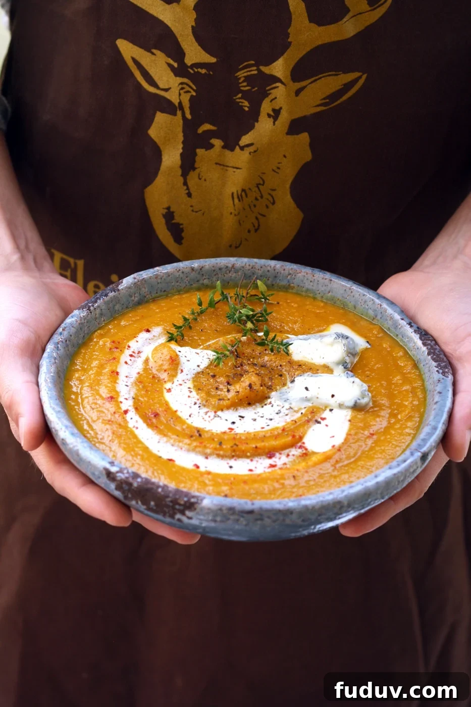 Hands Holding a Bowl of Vegan Butternut Squash Soup.