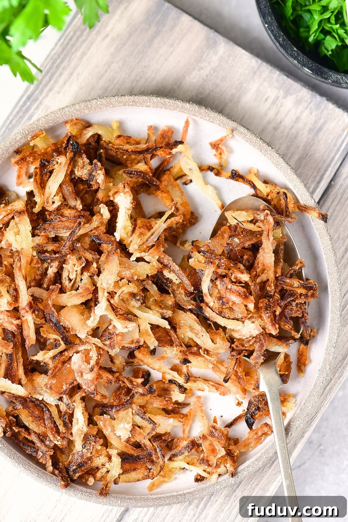 A plate of gluten-free fried onions on wooden board.