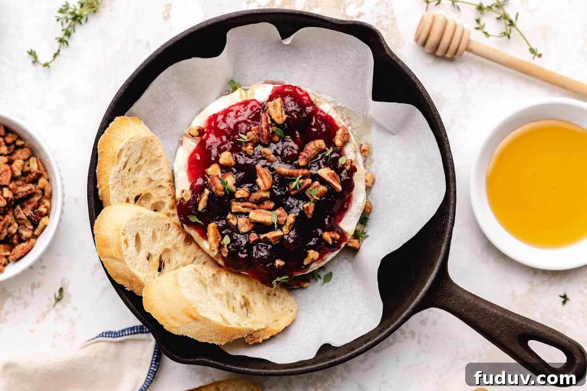 Top down view of brie, cranberry sauce and pecans.
