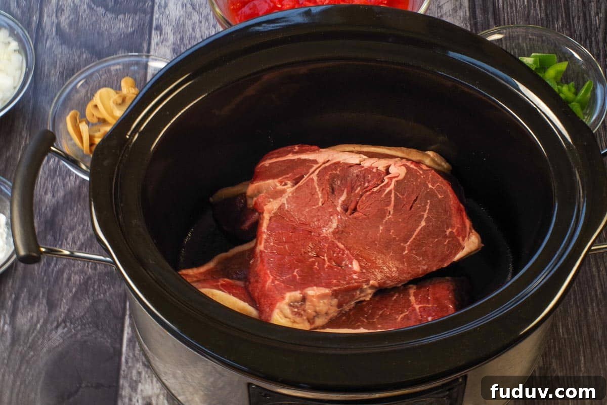 Steak in the bottom of a slow cooker