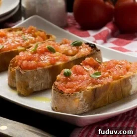 Pan con Tomate: Classic Spanish Tomato Toast Recipe 7 A white rectangular plate with 3 slices of Spanish bruschetta or pan con tomate on it on a red and white tea towel