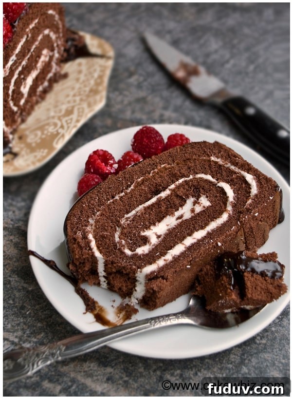 Slice of Chocolate Roll Cake in White Plate with Spoonful Removed