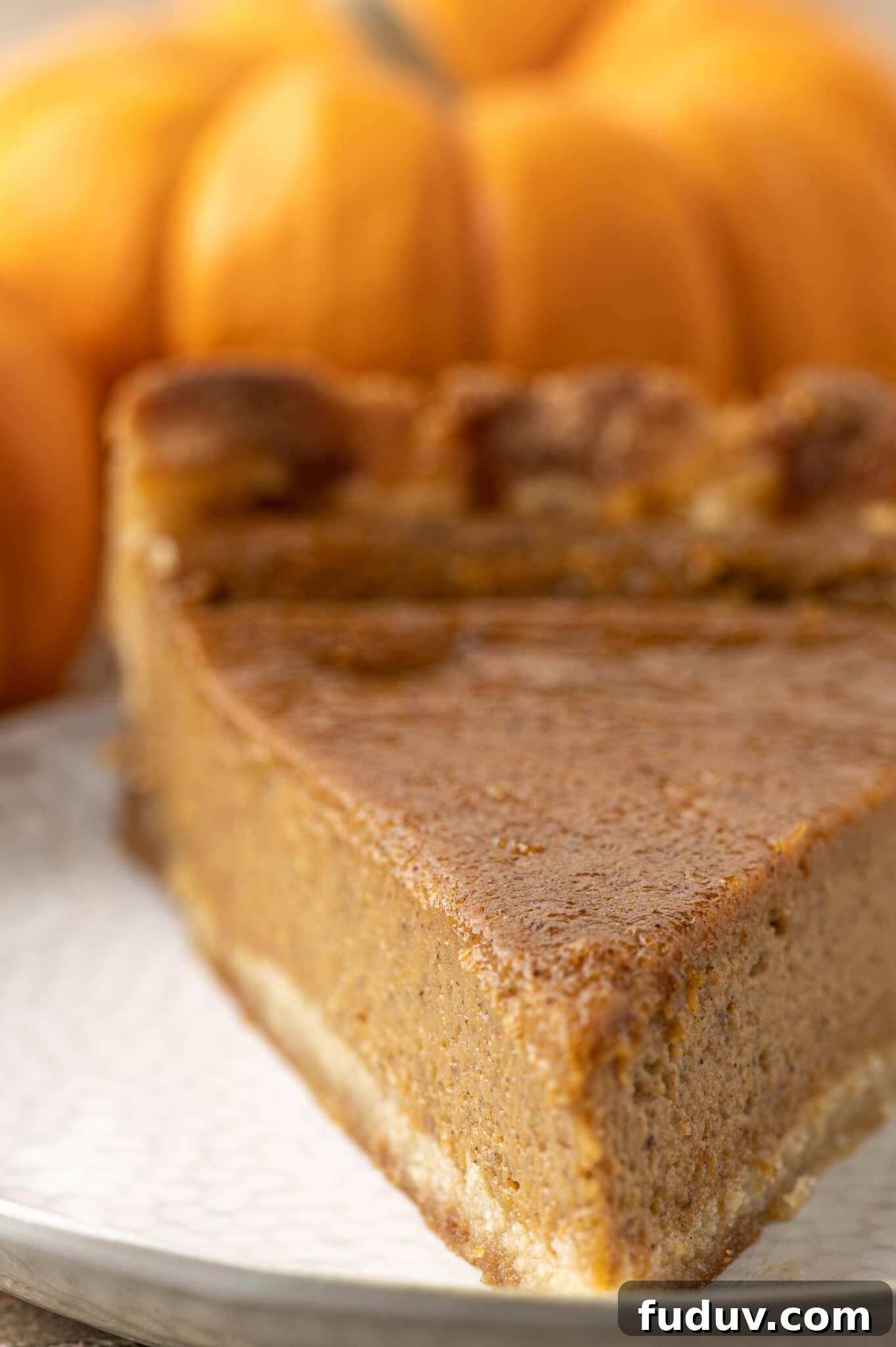Sugar-Free Pumpkin Pie Recipe for Fall Holidays 3 A slice of sugar free pumpkin pie with orange pumpkins in the background