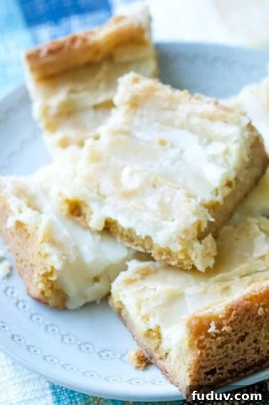 close up of ooey gooey cake bars stacked on a plate