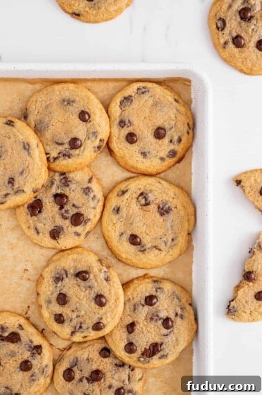 Crispy chewy chocolate chip cookies on a baking sheet.