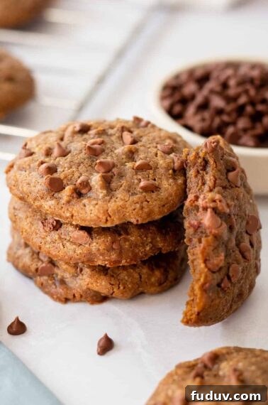 A stack of coffee cookies with one next to it missing a bite.