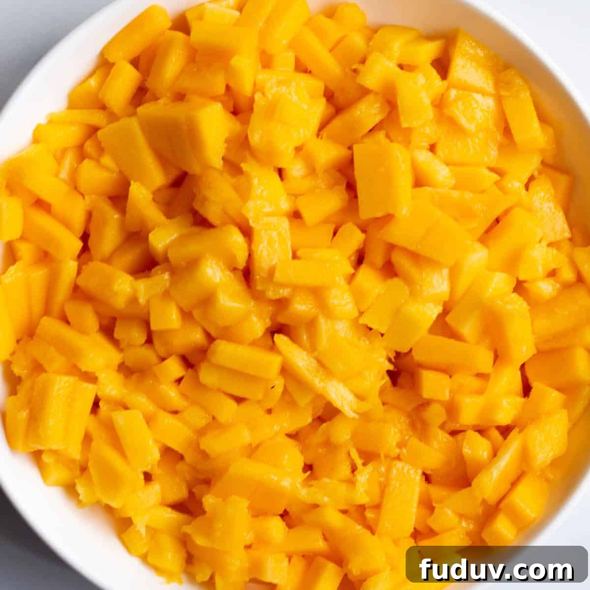A bowl of diced up mangos.
