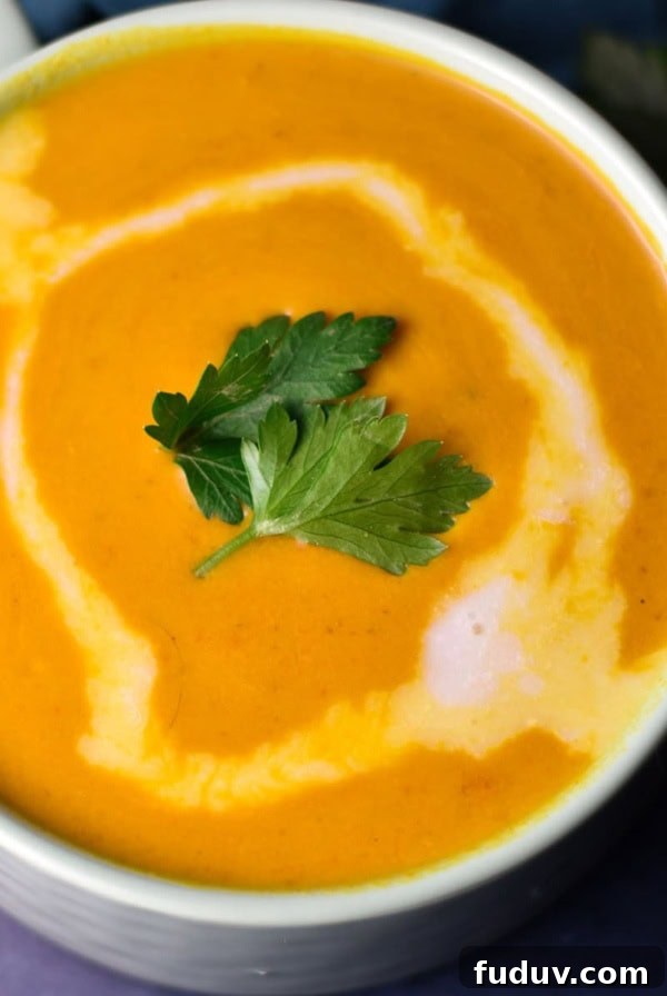 Sweet potato and red pepper soup in a green cup.