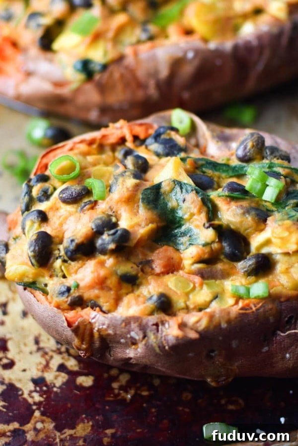 A mexican stuffed sweet potato on a sheet pan topped with green onion slices