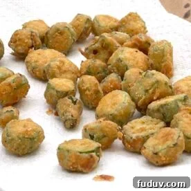 Cornmeal crusted fried okra draining on a paper towel.