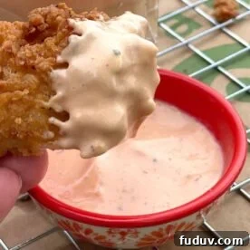 A chicken tender coated in boom boom fry sauce.