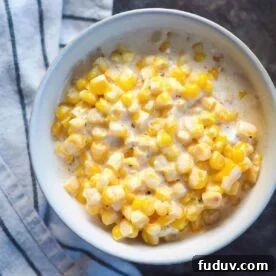 A white bowl of creamed corn.