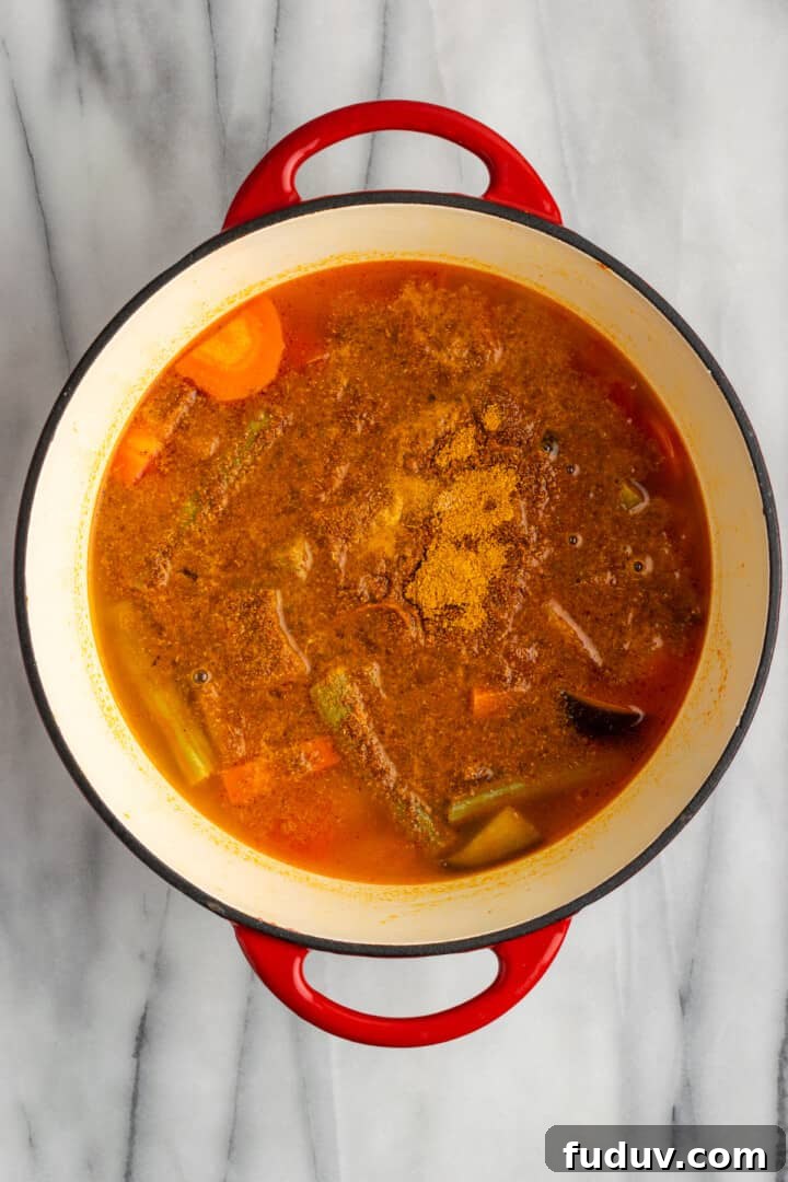 Overhead view of sambar in Dutch oven, after adding spices