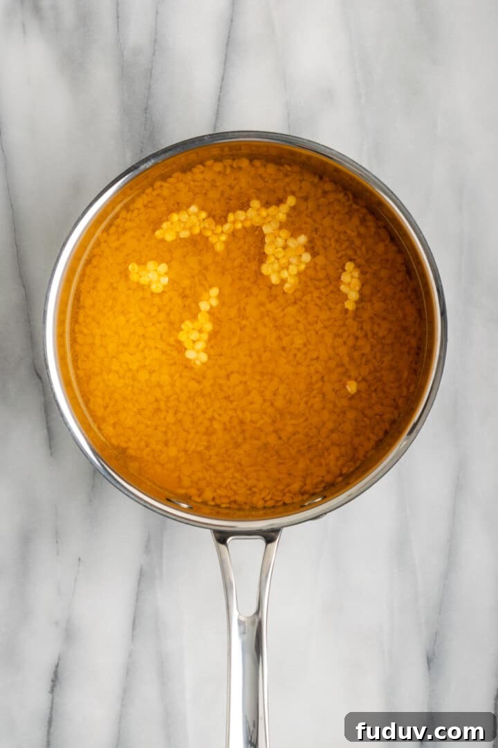 Overhead view of lentils and water in saucepan