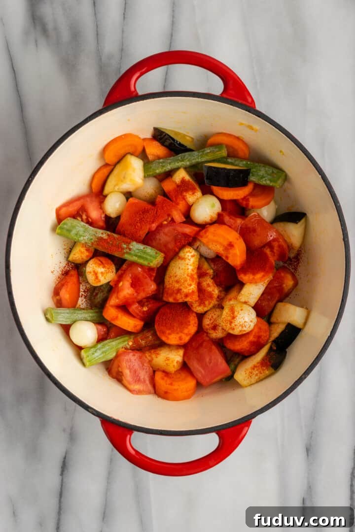 Overhead view of vegetables and red chili powder in Dutch oven