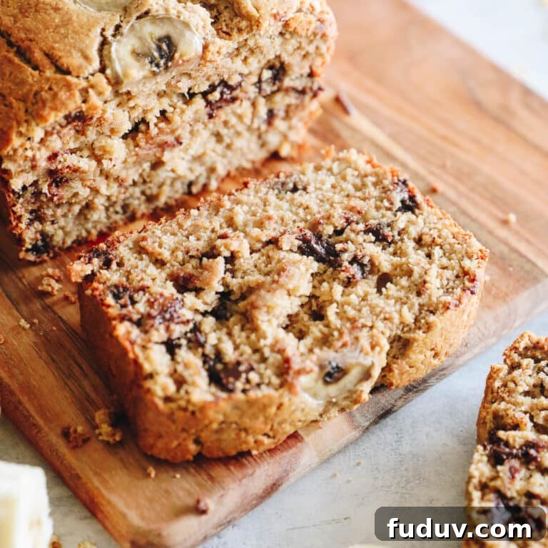 up close image of a slice of oat flour banana bread on a cutting board.