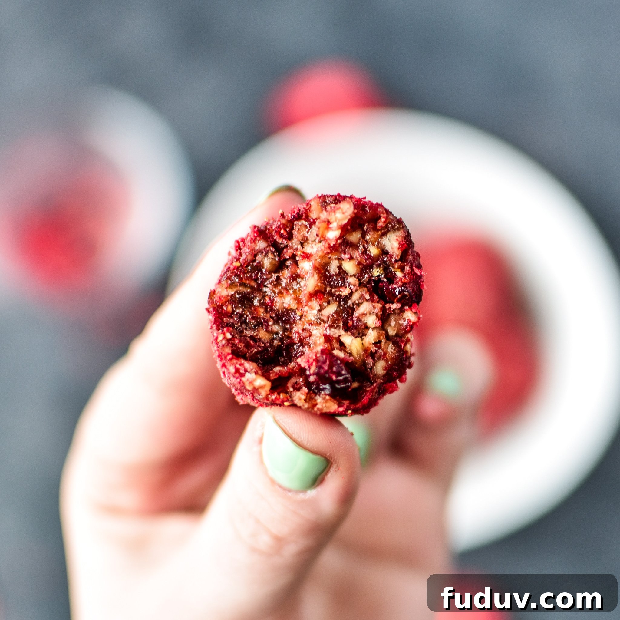 Spiced Berry Energy Balls: No-Bake Snack Recipe 7 A hand holding a spiced berry bliss ball.