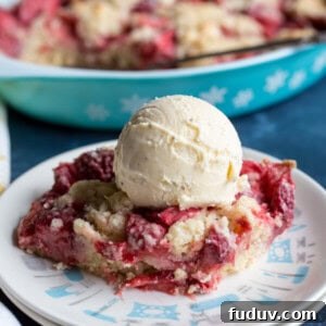 Strawberry dump cake on a plate with a scoop of vanilla ice cream on top