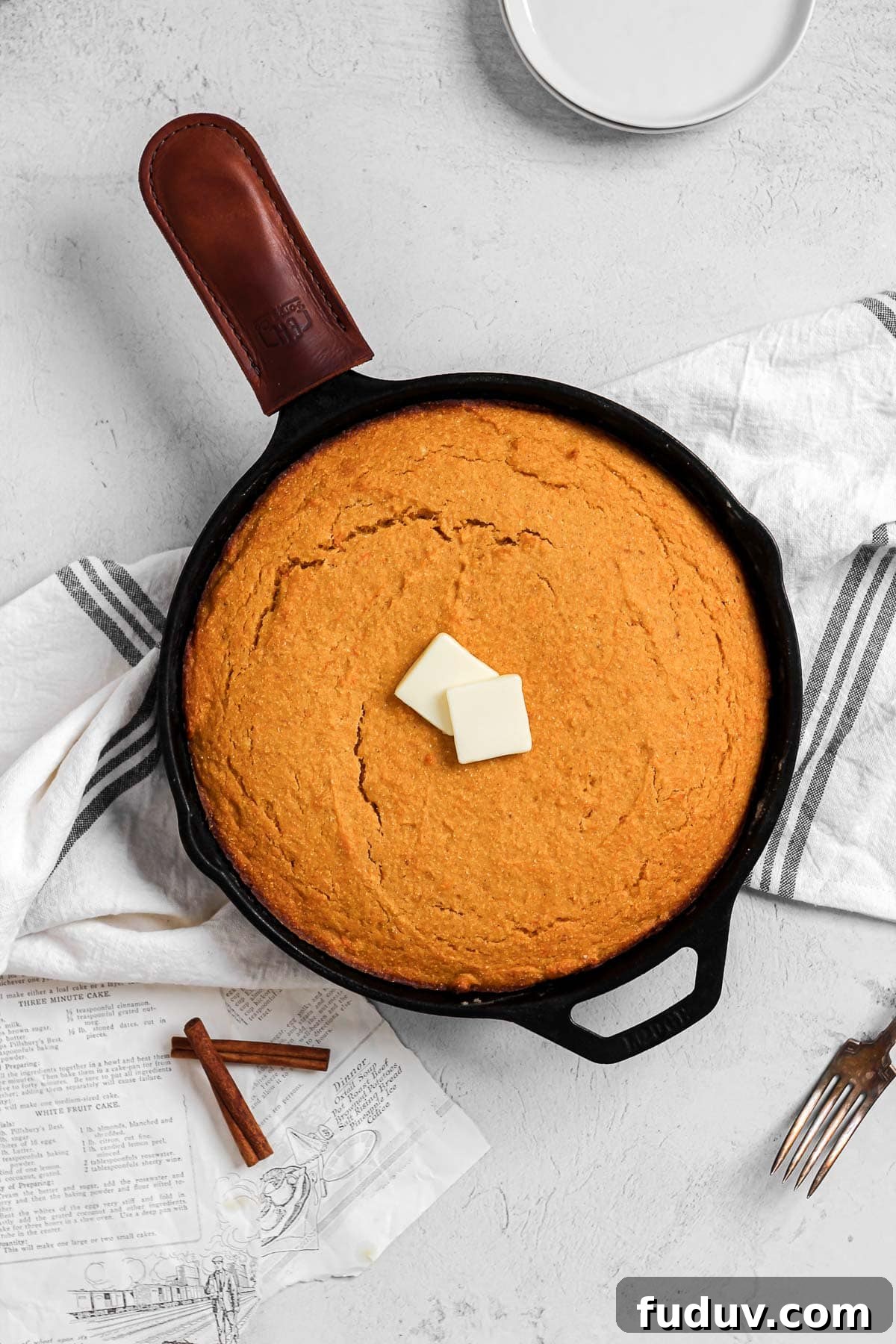 Sweet Potato Cornbread Recipe with Maple Butter Glaze 2 sweet potato cornbread in a cast iron skillet with butter