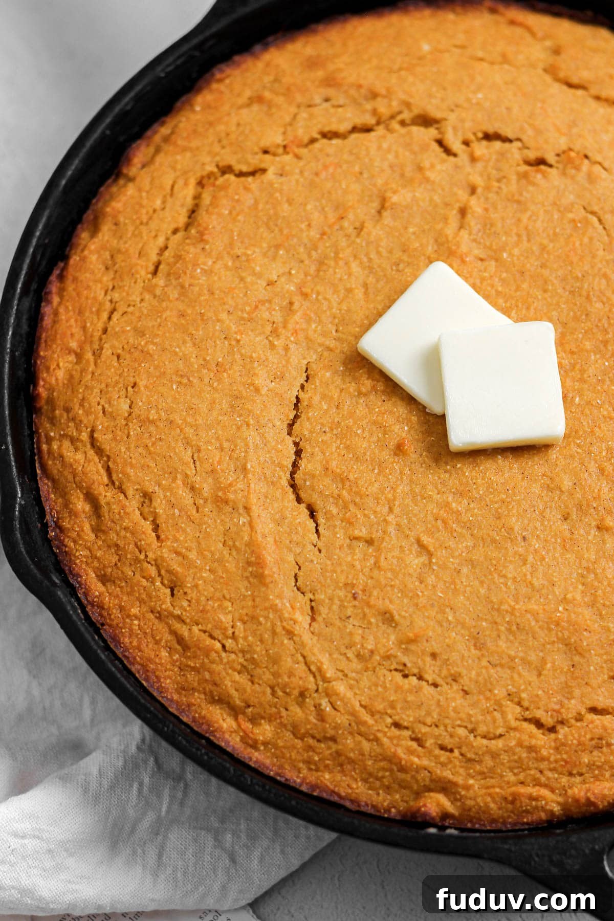 Sweet Potato Cornbread Recipe with Maple Butter Glaze 4 sweet potato cornbread in a cast iron skillet with butter