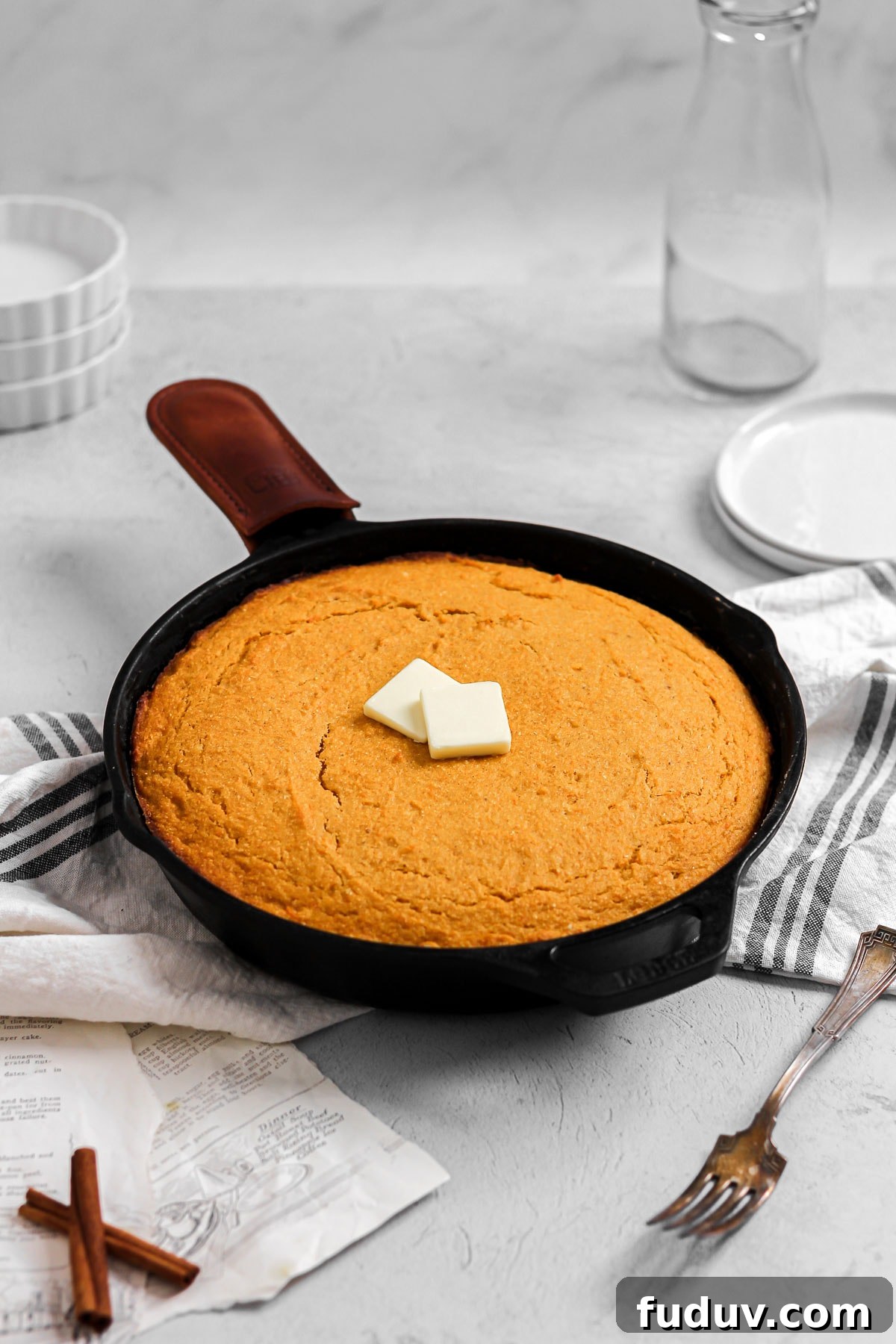Sweet Potato Cornbread Recipe with Maple Butter Glaze 6 sweet potato cornbread with butter in a cast iron skillet