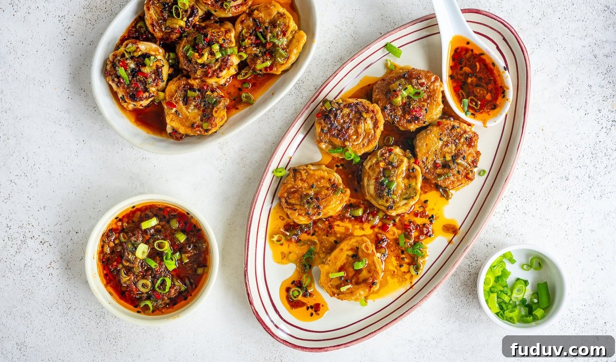 Crispy Homemade Dumpling Rolls: Step-by-Step Recipe 4 Two plates of pan-fried dumplings topped with chopped green onions and chili oil, with bowls of dipping sauce and sliced green onions, arranged on a white surface.
