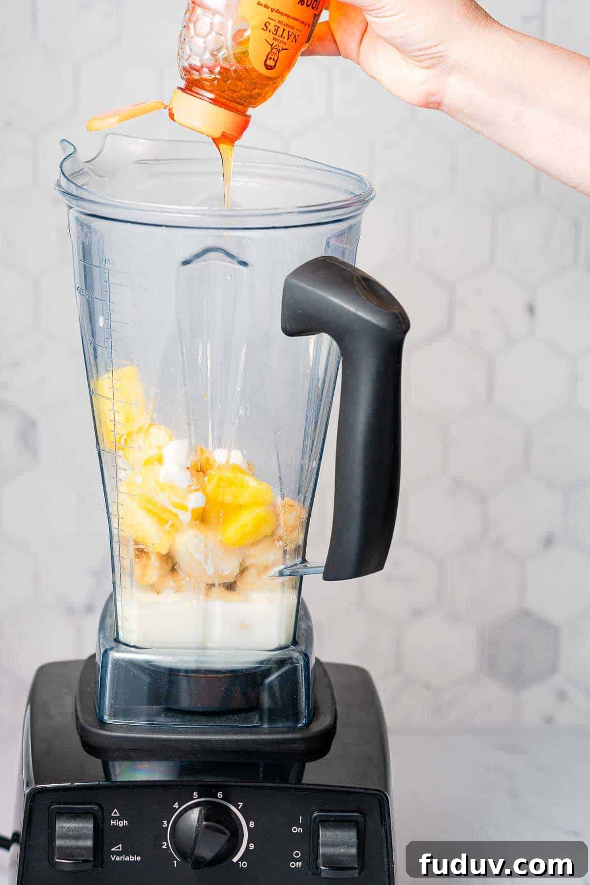 honey being drizzled into blender