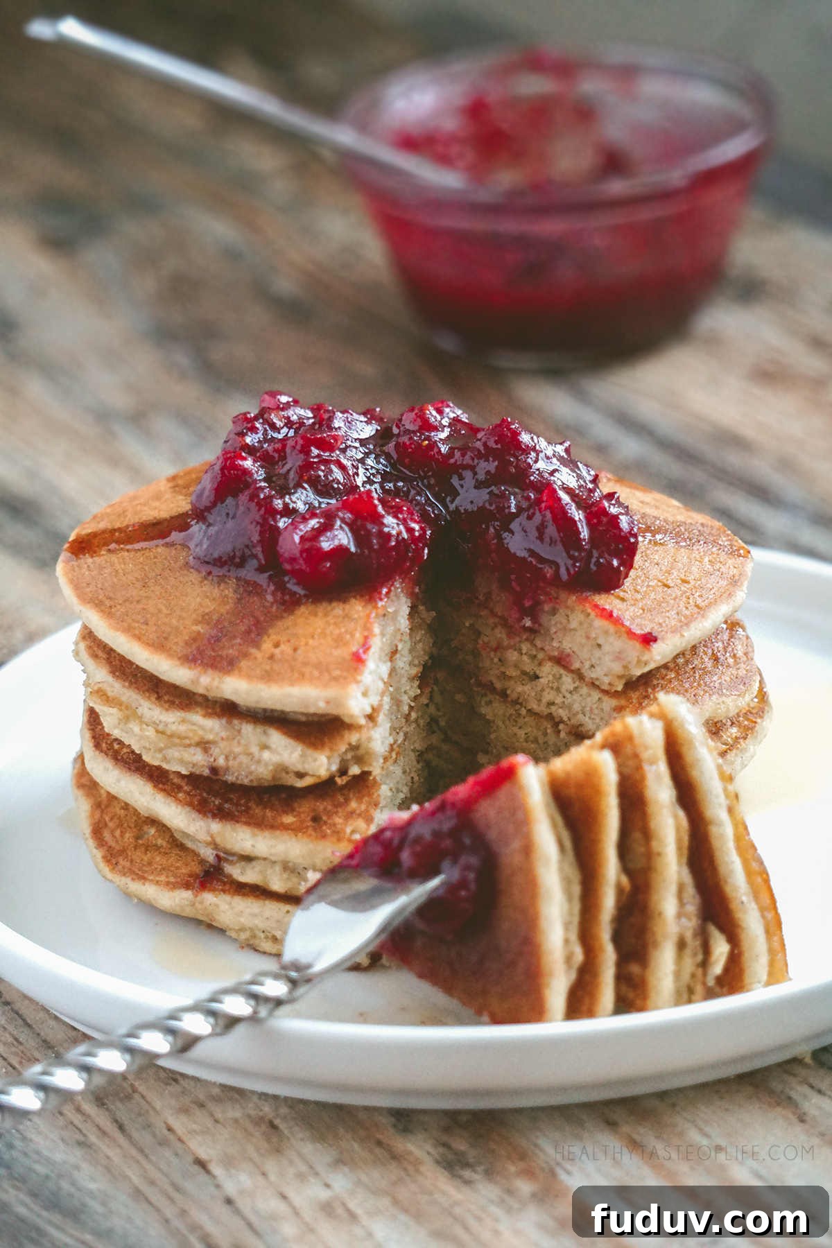Gluten-Free Sourdough Pancakes — Light, Fluffy & Dairy-Free 2 Stack of gluten free sourdough pancakes cut - fluffy soft inside, topped with a cranberry sauce.