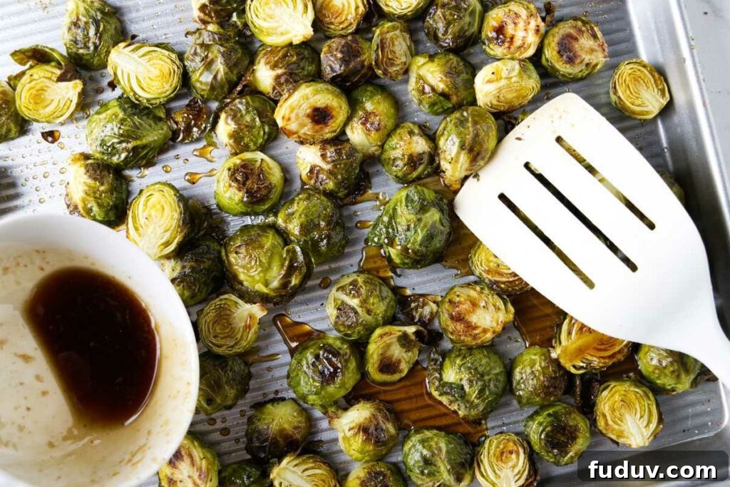 Honey Sriracha Roasted Brussels Sprouts 6 Drizzling honey sriracha sauce over Brussel sprouts on a sheet pan.