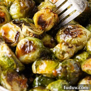 Honey Sriracha Roasted Brussels Sprouts 8 A fork in a dish with honey sriracha brussel sprouts.