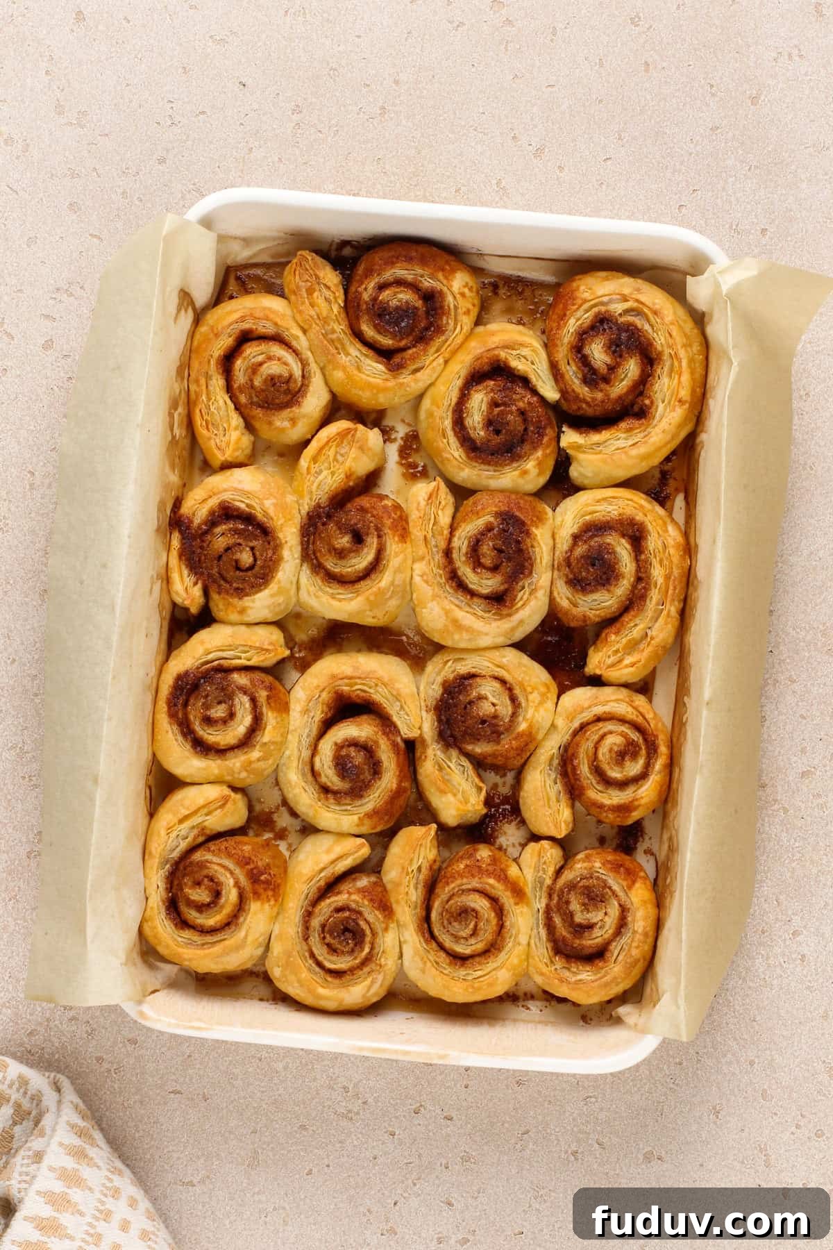 Freshly baked puff pastry cinnamon rolls in a baking pan.