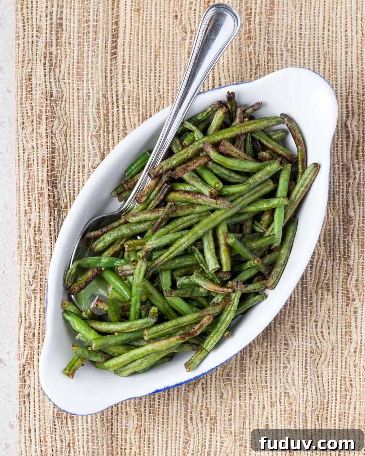 Crispy Air-Fried Frozen Green Beans with Creamy Tahini Sauce 15 Overhead photo showing a dish of air fried frozen green beans with a spoon ready for serving.