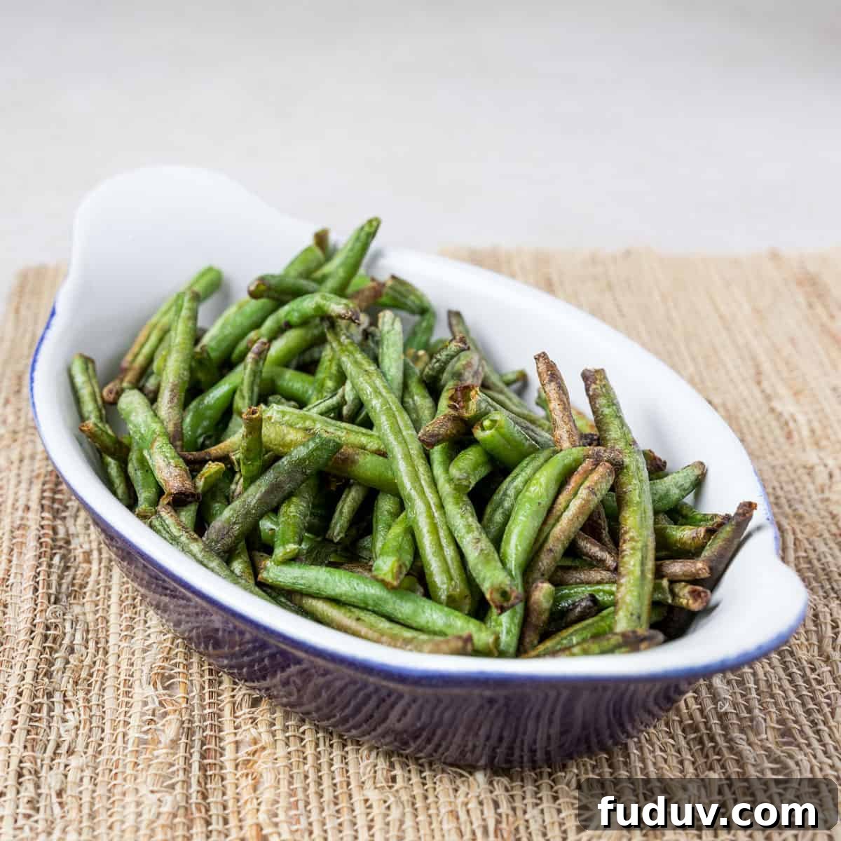 Crispy Air-Fried Frozen Green Beans with Creamy Tahini Sauce 4 Photo showing a dish of air fried green beans on a bamboo mat.