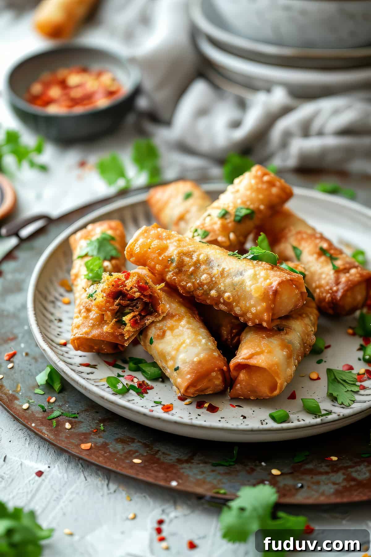 Easy vegetable spring rolls with dipping sauce on a white plate.