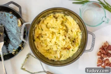 Mashed Potatoes mixed with cabbage and bacon inside dutch oven skillet.