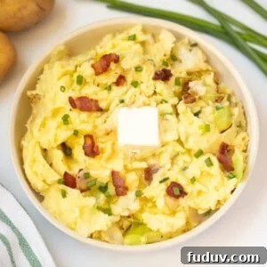 Colcannon in serving dish topped with a pat of butter and bacon.