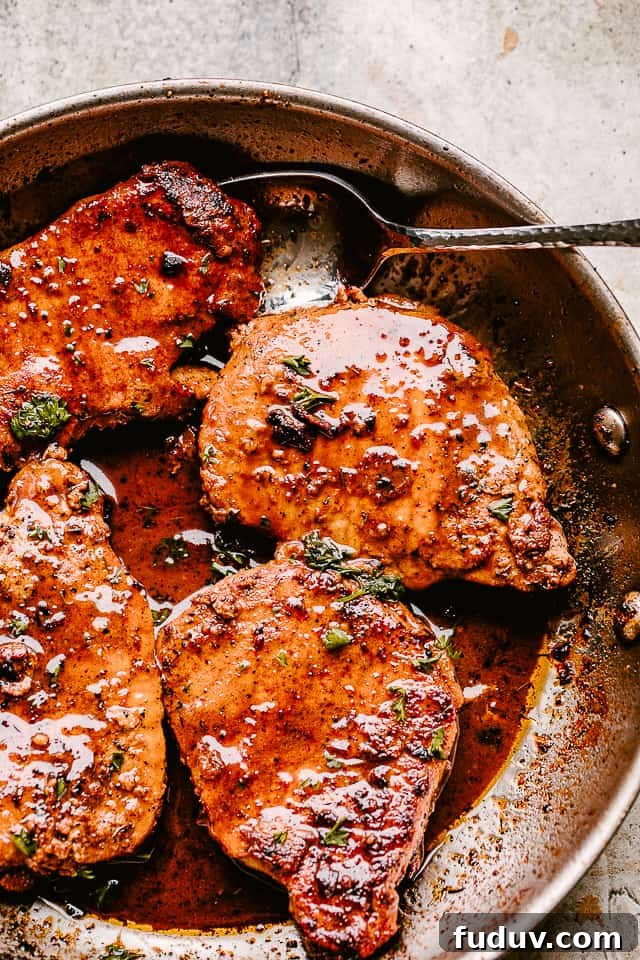 Juicy, tender, and flavorful, these garlic parmesan pan fried pork chops are smothered in a rich honey garlic sauce. Done in just 20 minutes! Skillet with pan fried pork chops