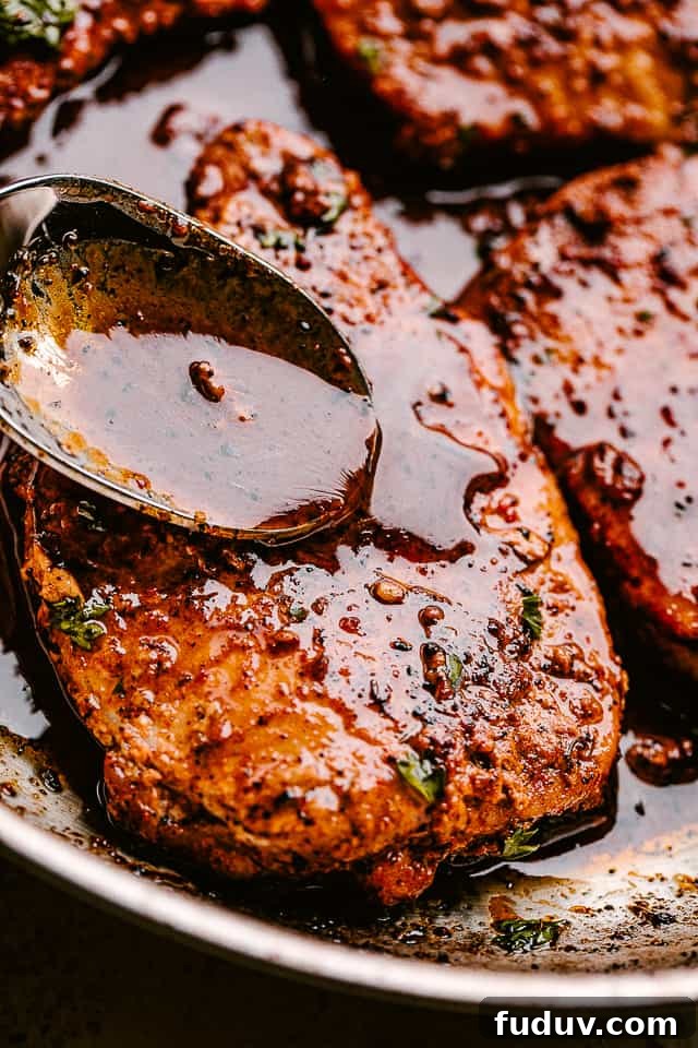 Juicy, tender, and flavorful, these garlic parmesan pan fried pork chops are smothered in a rich honey garlic sauce. Done in just 20 minutes! Spooning sauce over pan fried pork chops