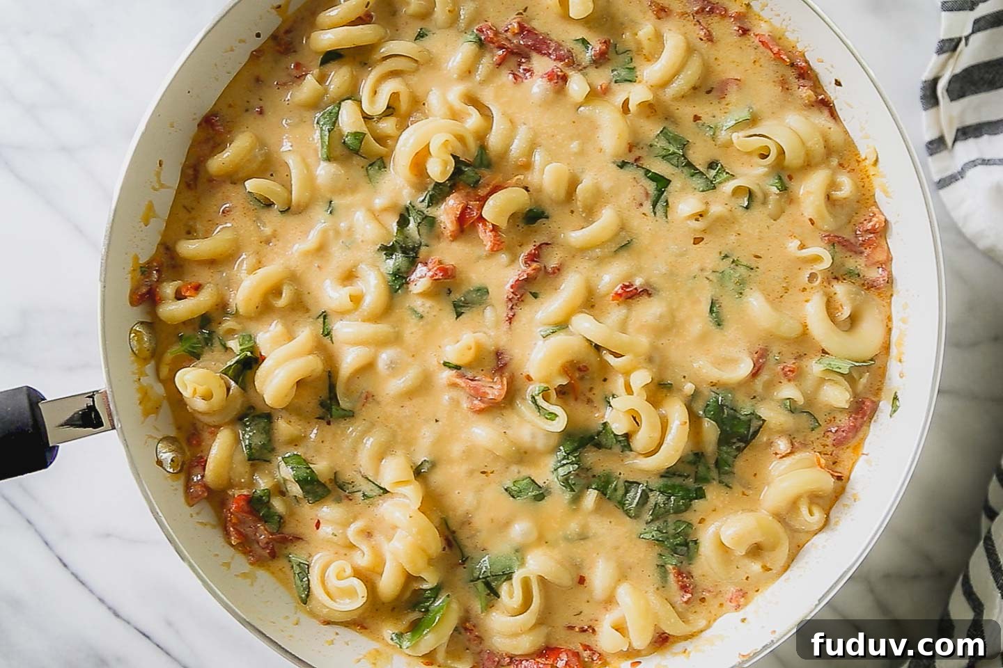 Sun-dried tomato and basil pasta in a skillet.