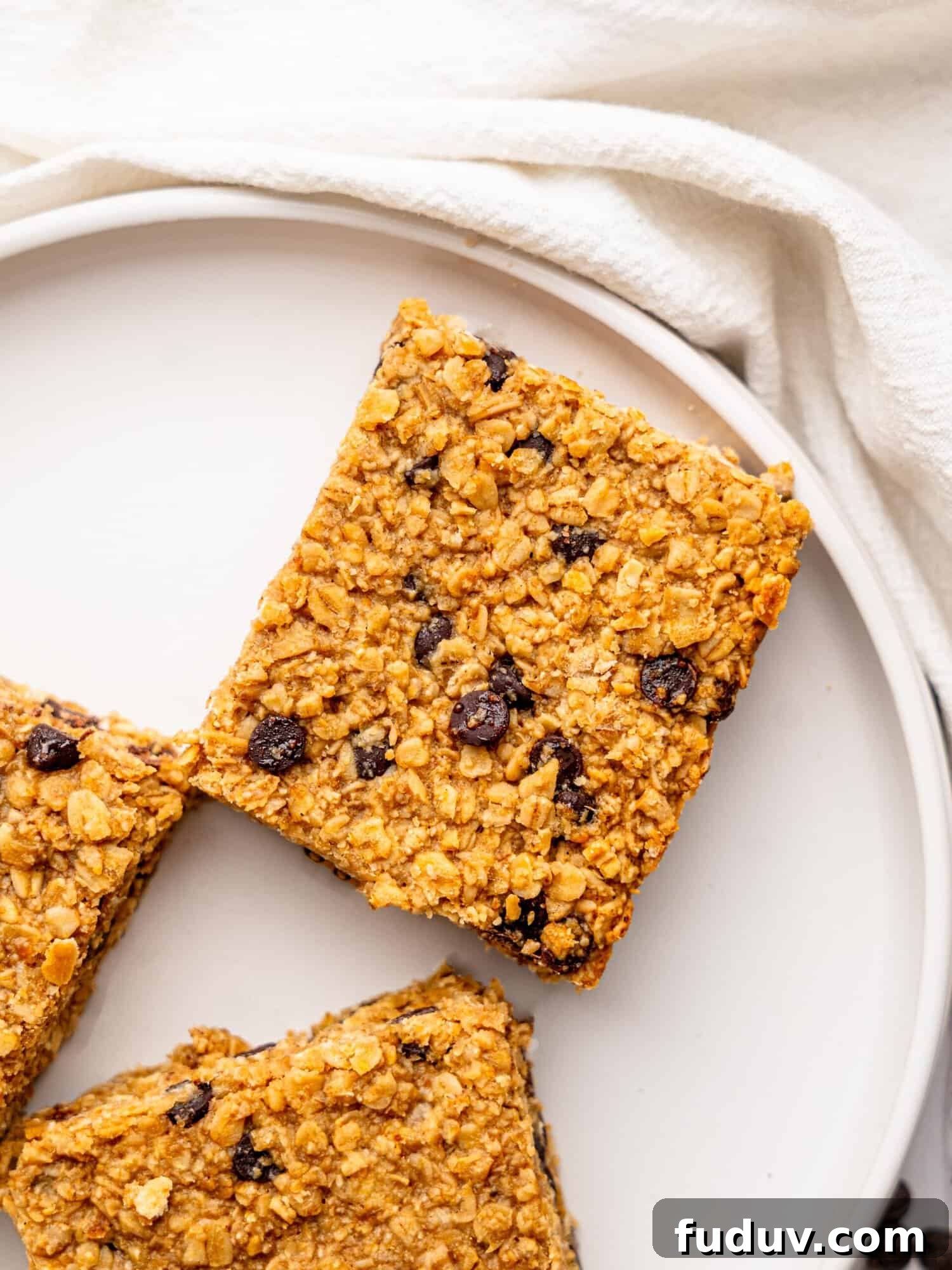 Bird's eye view of three healthy flapjacks on a white plate.