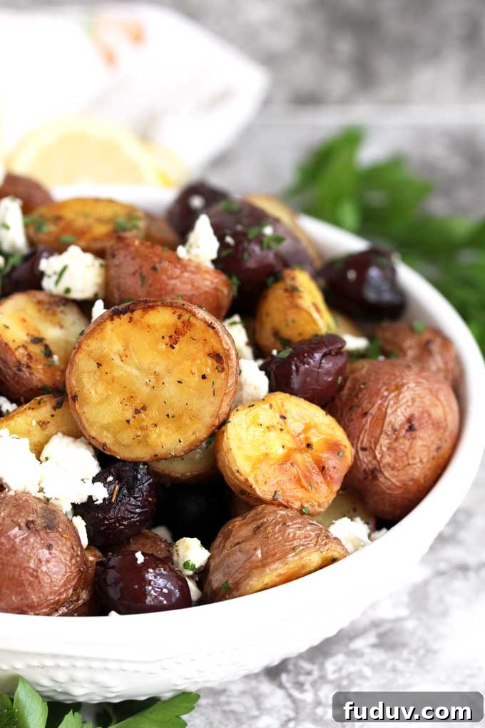 Crispy Greek-Style Roasted Potatoes with Lemon and Oregano 3 Greek Potatoes with Kalamata olives and feta cheese in a white bowl.