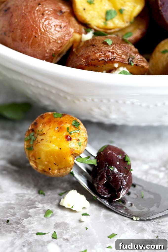 Crispy Greek-Style Roasted Potatoes with Lemon and Oregano 5 A golden Greek potato with a kalamata olive and feta cheese.