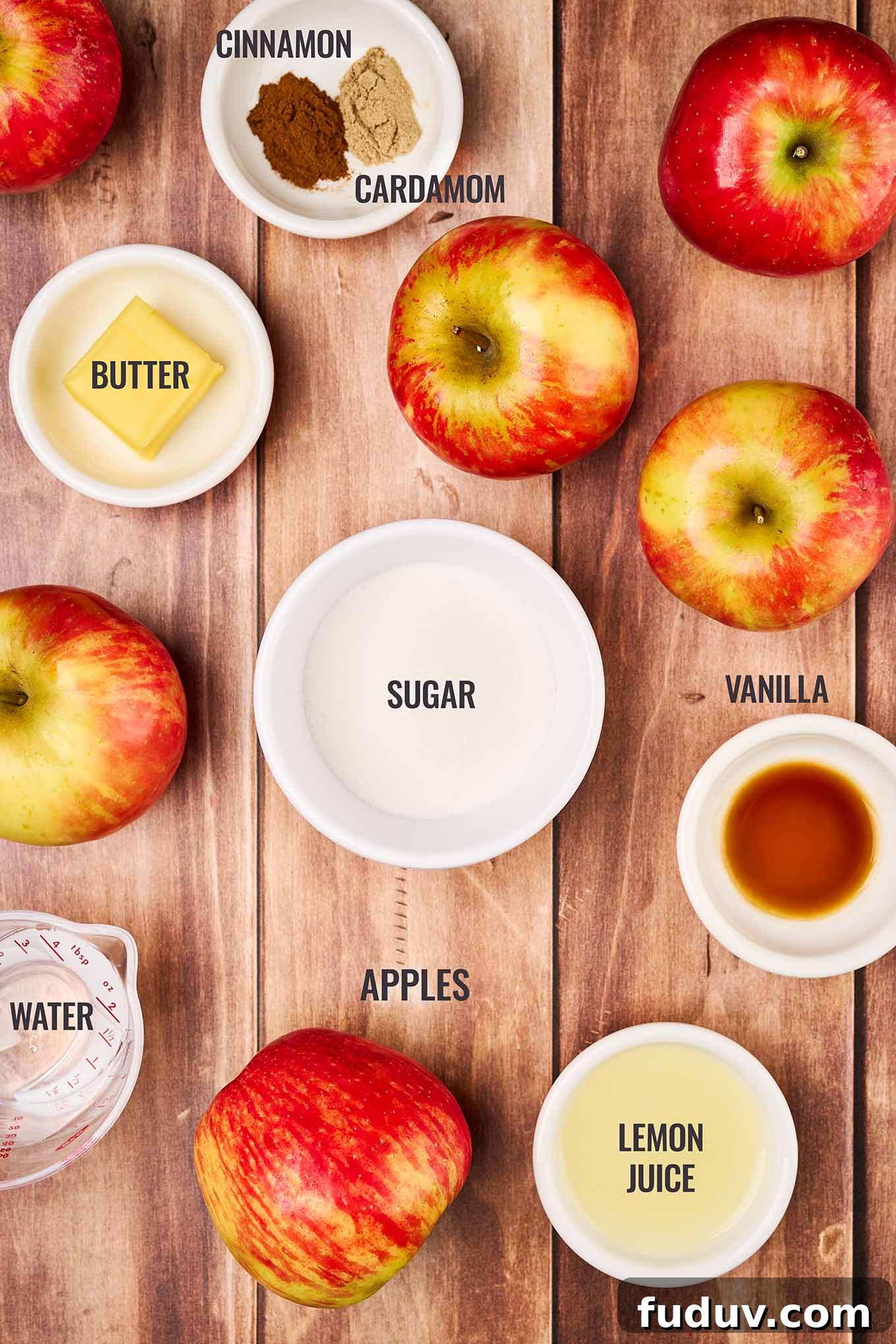 Homemade Cinnamon Applesauce Recipe: Warm Spice & Comfort 3 A labeled, overhead view of the ingredients for homemade applesauce including whole apples, lemon juice, sugar, vanilla, water, butter, and cinnamon.