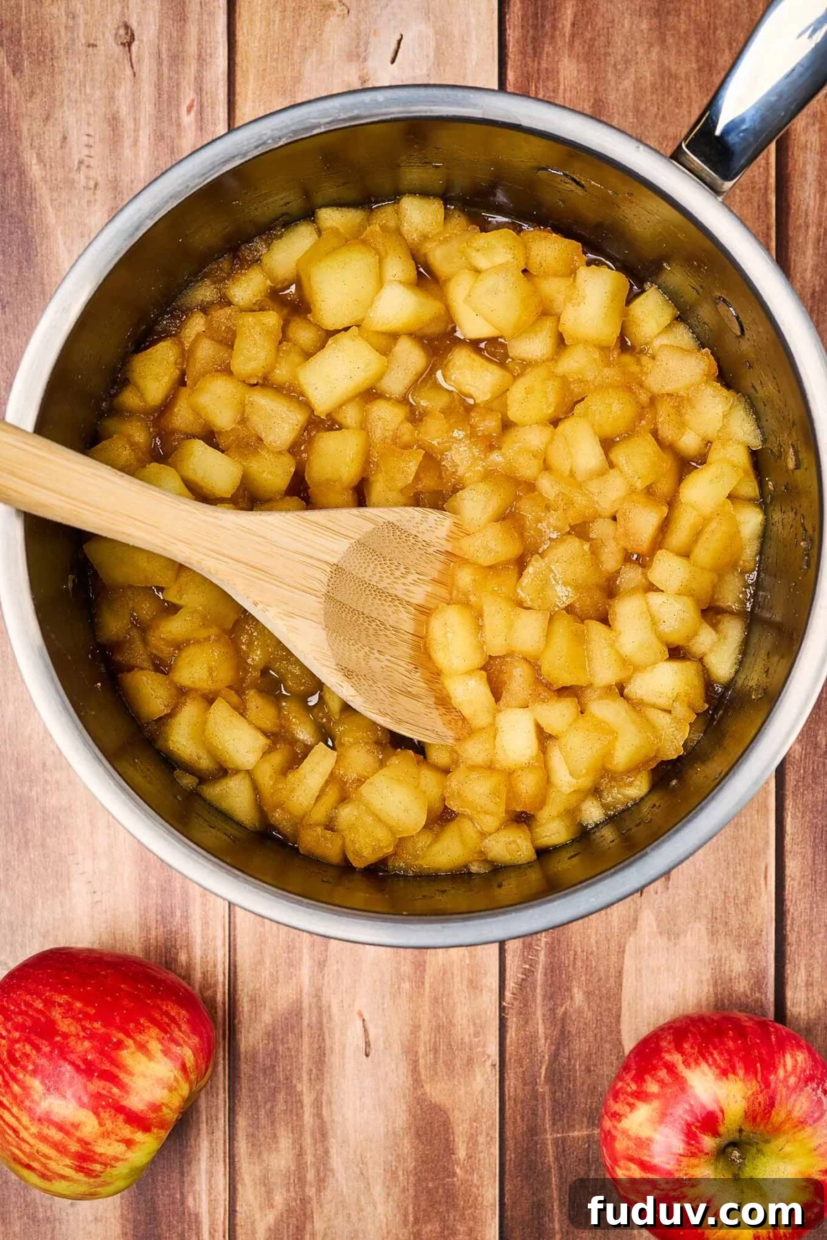 Homemade Cinnamon Applesauce Recipe: Warm Spice & Comfort 5 A saucepan filled with the ingredients for cinnamon applesauce, showing how the apples begin to break down into sauce as they cook.