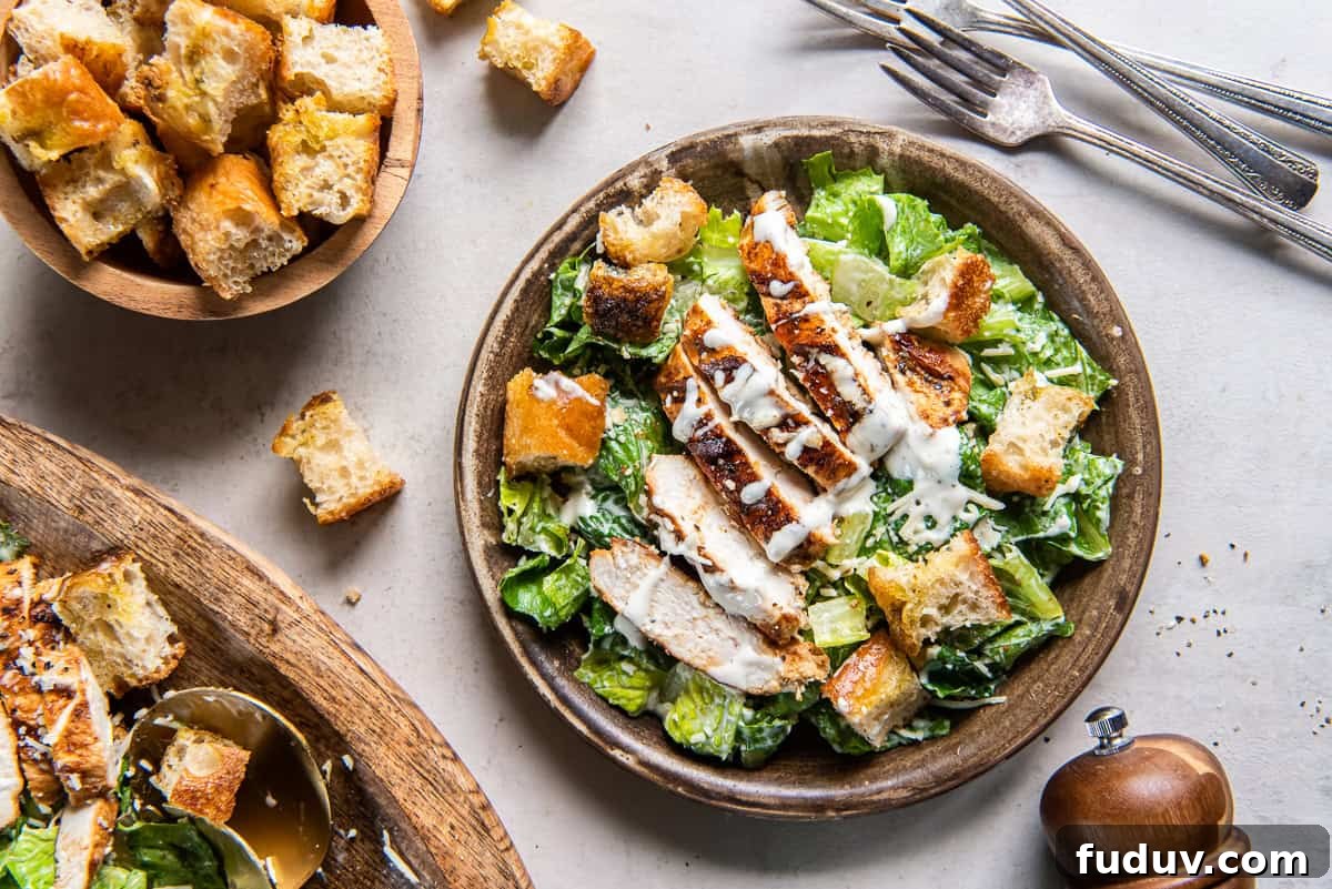 A serving of grilled chicken Caesar salad with focaccia croutons on a salad plate.