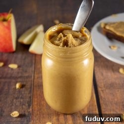 Homemade Nut Butter: Complete Guide to Smooth, Creamy Recipes 3 a jar of peanut butter in front of a sliced apple and plate