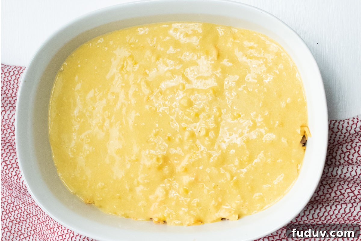 White casserole dish with a topping of cornbread batter