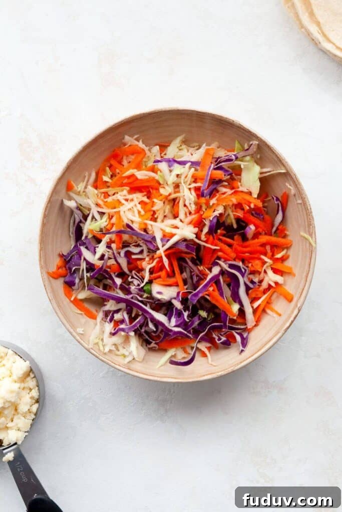 healthy carrot cabbage slaw in a mixing bowl